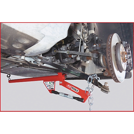 Rotes Werkzeug zum Ausdrücken von Kugelgelenken an einem Autoreifen.