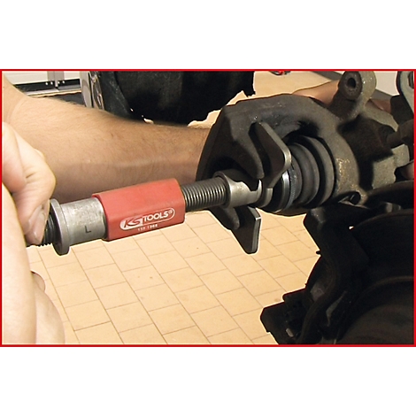 Eine Person verwendet ein KS TOOLS Werkzeug, um an einer Fahrzeugbremse zu arbeiten.