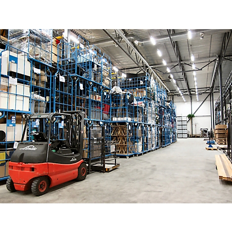 A warehouse with shelves filled with goods. A red forklift is in the foreground.