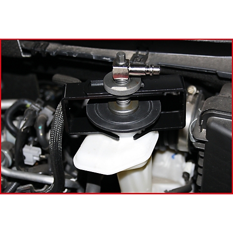 Detailaufnahme: Werkzeug an einem Motorraum, an einer weißen Flüssigkeitsbehältervorrichtung befestigt. Schwarz, Metall, grau.
