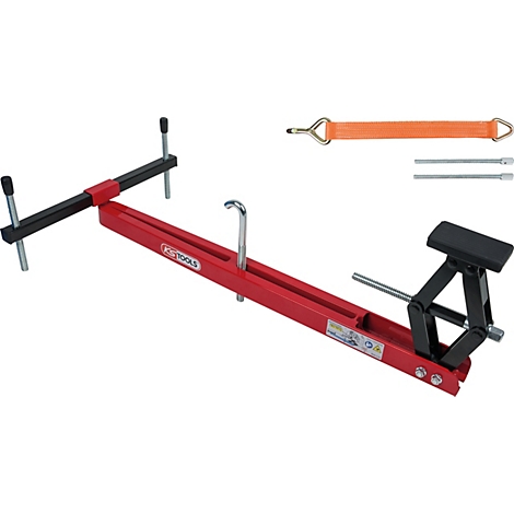 Ein rotes und schwarzes Werkzeug zur Verwendung im Fahrzeugbau, daneben ein orangefarbener Spanngurt.