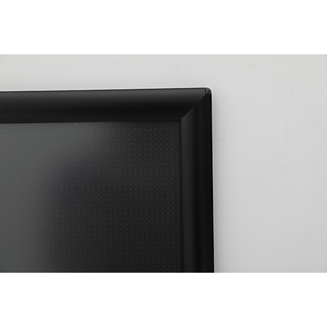 Gros plan d'une surface noire texturée encadrée par un cadre noir. Le fond est blanc.