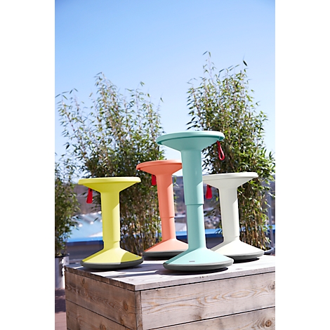 Four colorful standing aids stand outdoors in front of bamboo. Each standing aid has a round seat, a foot, and a red handle.