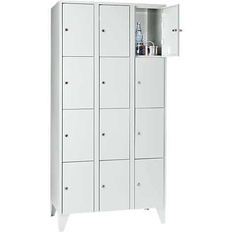 White cabinet with 12 compartments, one open with bottle and metal container.