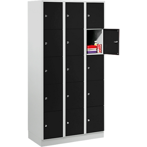 Cabinet with multiple compartments, one door open with contents. Black and white.