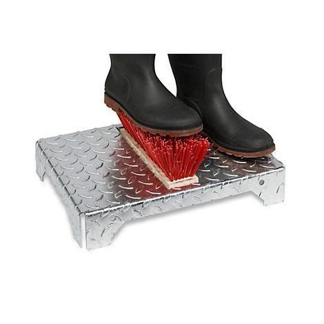 Laarzen op een metalen schraper met rode borstel, voor reiniging.