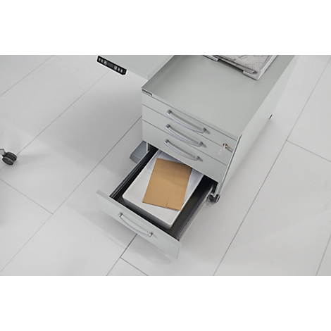 Grijze rolcontainer met drie laden, waarvan één open met papier. Op een lichte vloer, bovenaanzicht.