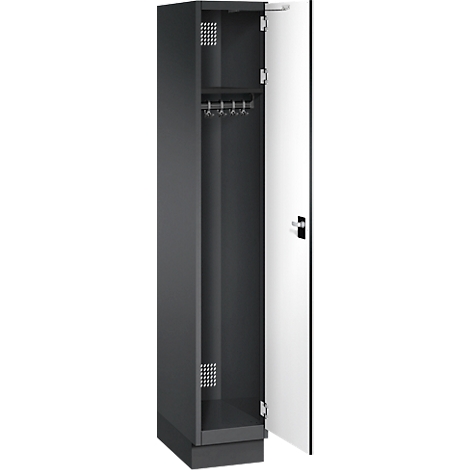 Armoire noire ouverte avec porte blanche. A l'intérieur, il y a une tringle à vêtements et de petits trous de ventilation.