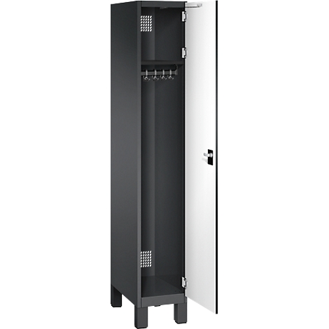 Armoire sombre avec porte blanche ouverte. À l'intérieur, une étagère, une tringle à vêtements, un motif de trous. Repose sur des pieds.