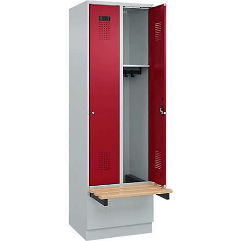 Un vestiaire ouvert avec portes rouges, banc en bois clair et fentes d'aération.