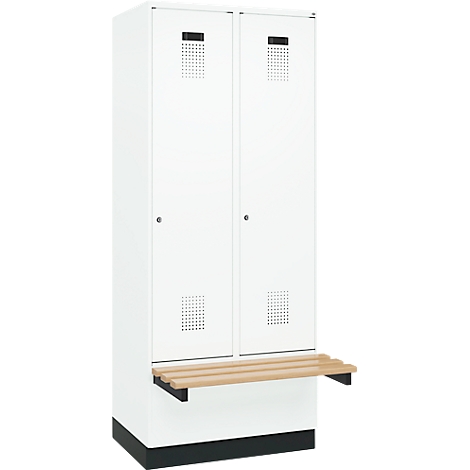 Casier blanc avec banc. Fentes de ventilation en haut, motif en grille en dessous. Lattes en bois formant l'assise.