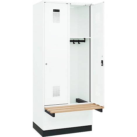 Casier blanc, une porte ouverte, avec tringle à vêtements, banc et fentes d'aération.