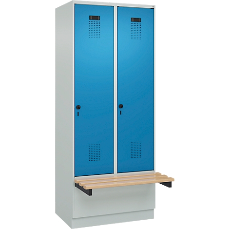 Portes d'armoires bleues avec étagère. Poignées noires, fentes d'aération, étagère en bois clair.