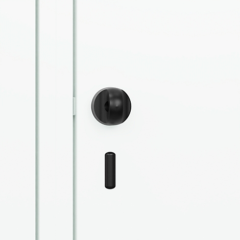 Bouton de porte noir et trou de serrure sur une porte blanche.