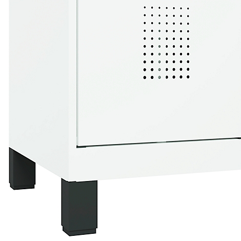 Gros plan d'une armoire blanche avec des pieds foncés et un panneau de trous ventilé.