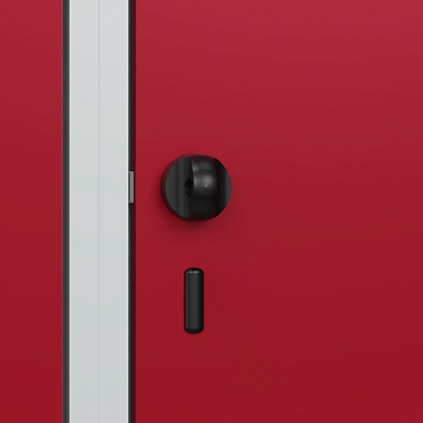 Gros plan d'une porte rouge avec un bouton de porte et un loquet noirs. Un cadre de porte blanc est à gauche.