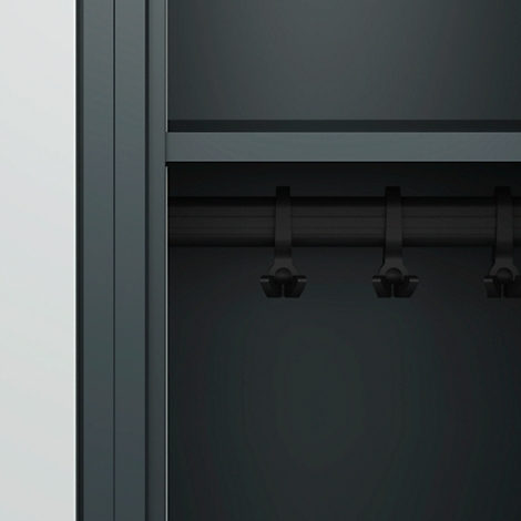 Intérieur d'armoire gris foncé avec une tringle à vêtements et des cintres. Le côté gauche est gris clair.