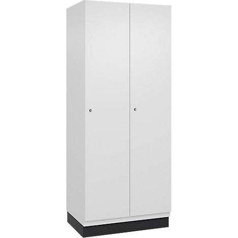 Armoire blanche à deux portes. Poignées grises, socle noir. Fond neutre.