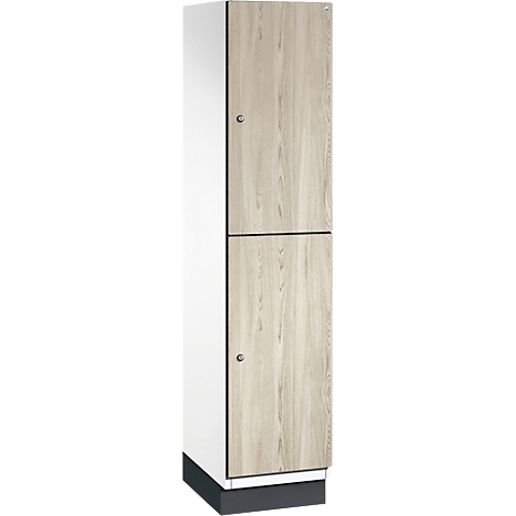 Armoire avec portes en bois brun clair, corps blanc, socle foncé et poignées argentées.