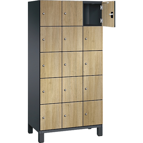 Casier en bois avec plusieurs compartiments, boutons argentés et une porte ouverte.