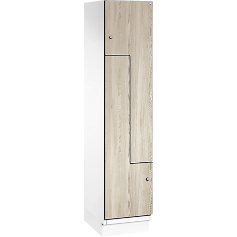 Armoire avec porte imitation bois et corps blanc. Munie de boutons et d'encoches rectangulaires.
