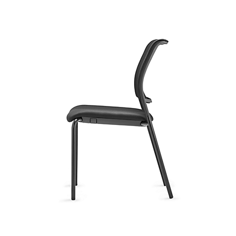 Black chair in profile. Seat and backrest are shaped, on a black metal frame.