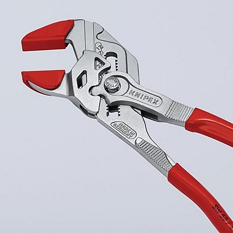 Close-up van een tang met rode handvatten en bekken. De merknaam KNIPEX is zichtbaar op de tang.
