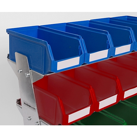 Close-up van opbergbakken in blauw, rood en groen. Op het metalen frame staat "Schäfer Shop".