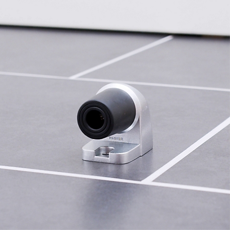 Detailopname van een zwarte camera met een zilveren houder op een grijze ondergrond.