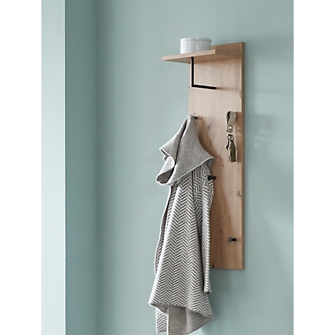 Holzwand mit Regal, Kleiderhaken, Schlüsselanhänger und grauer Jacke. Auf dem Regal steht ein weißer Behälter.