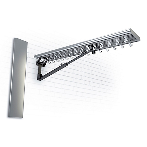 Wäschetrockner, an einer Wand befestigt, aus silberfarbenem Metall. Schwarze Gelenkarme. Helle Backsteinmauer.