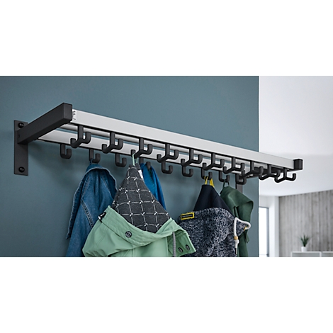 Kapstok met zwarte haken, waaraan jassen hangen. Grijze muur op de achtergrond.