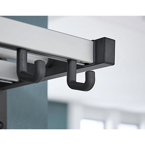 Close-up van zwarte haken die onder een witte rail hangen.