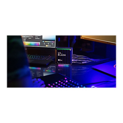 Auf einem Schreibtisch mit RGB-Beleuchtung steht ein WD-Black-Laufwerk. Ein Spieler ist am Computer aktiv.