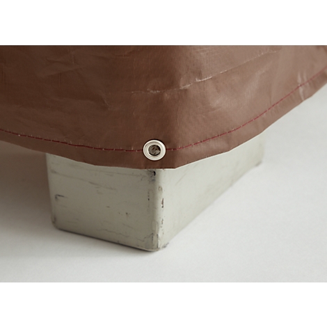 Brown tarpaulin with red seam, metal eyelet, on gray cuboid.