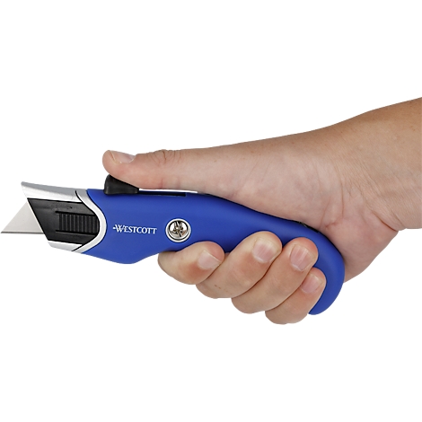 A hand holding a blue Westcott utility knife. The blade is extended. The Westcott logo is visible on the knife.