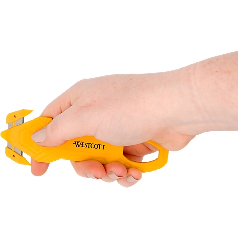 Hand holding a yellow Westcott safety cutter.