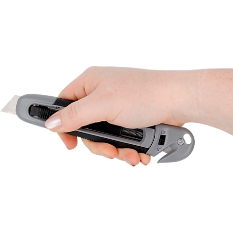 Eine Hand hält ein graues und schwarzes Cuttermesser, dessen Klinge sichtbar ist.
