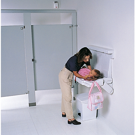 Mutter wickelt Baby auf weißer Wickelauflage. Eine Handtasche hängt an der Wickelauflage.