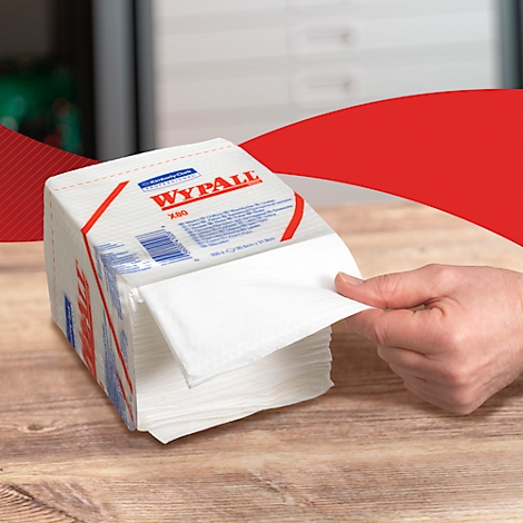 A stack of white WypAll wipes, a hand pulls one out. The logo and "X80" are on the packaging.