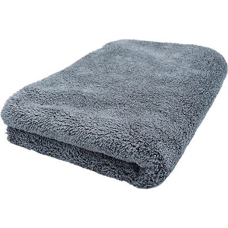 Une serviette en microfibre grise pliée. La surface est douce et duveteuse.