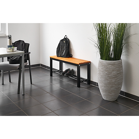 Hallway featuring a bench, chair, pot with tall grass, and shoes.