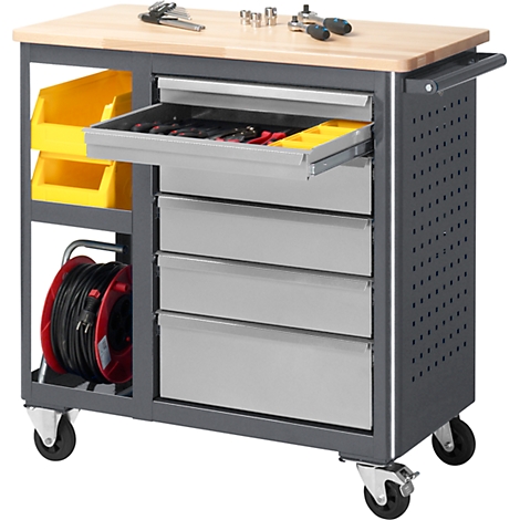 Tool cart with wooden top and drawers. Yellow containers, tools and cable reel. On wheels.