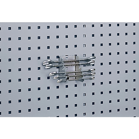 Several wrenches are attached to a pegboard with a holder.