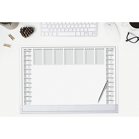 Top view of an empty weekly planner with pen on a white desk. Keyboard, mouse, and accessories are around.