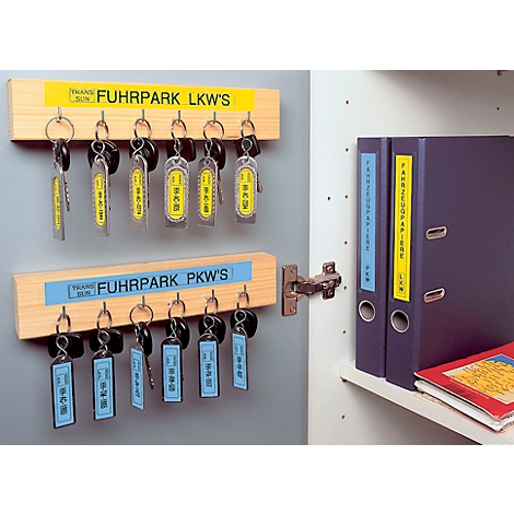 Key rack with keys for trucks and cars, next to folders in the closet.