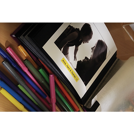 Photo album with black and white photo, colorful pens next to it. On yellow sign: Anna, Hans & Thomas :)