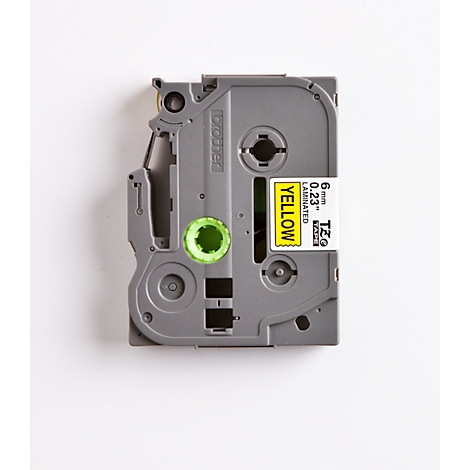 Gray label dispenser with yellow sticker. The sticker says "YELLOW" and other technical details.