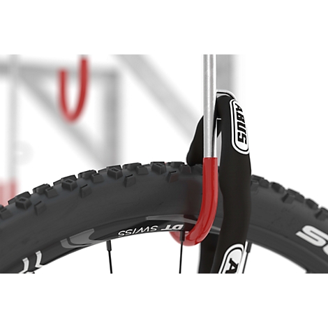 A bicycle tire with an ABUS lock secured to a red bracket.