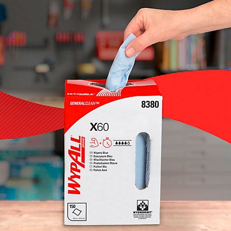 A hand pulls a blue wipe from a red and white WYPALL dispenser, set against a tool background in the background.